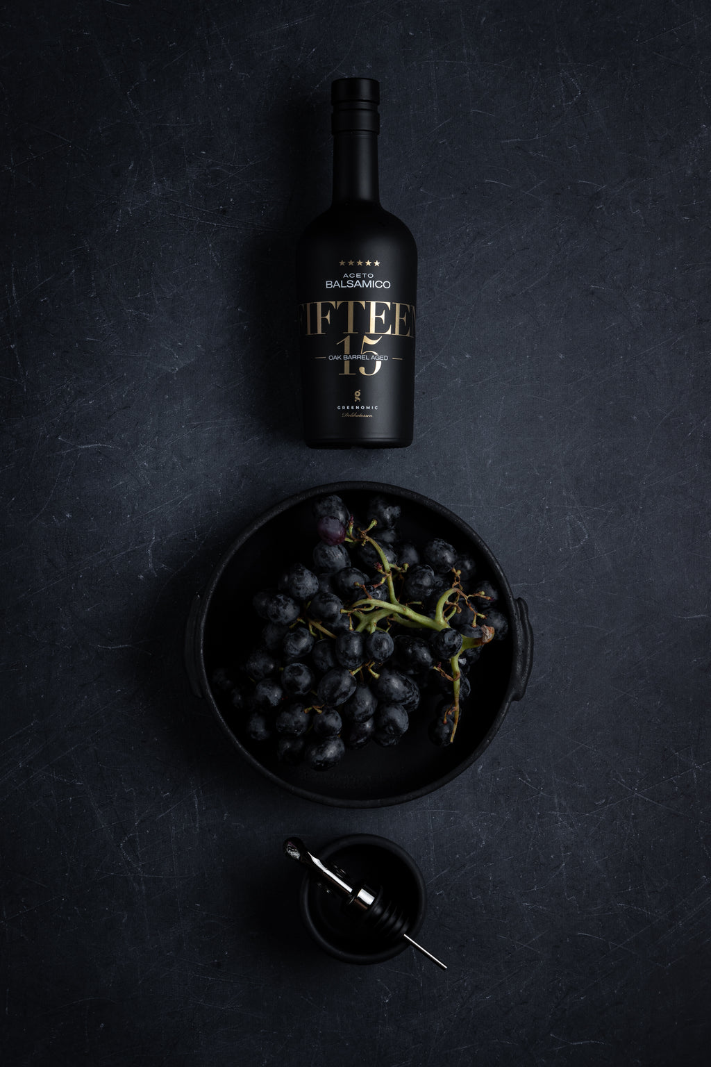 Balsamico FIFTEEN in schwarzer Keramikflasche mit Trauben
