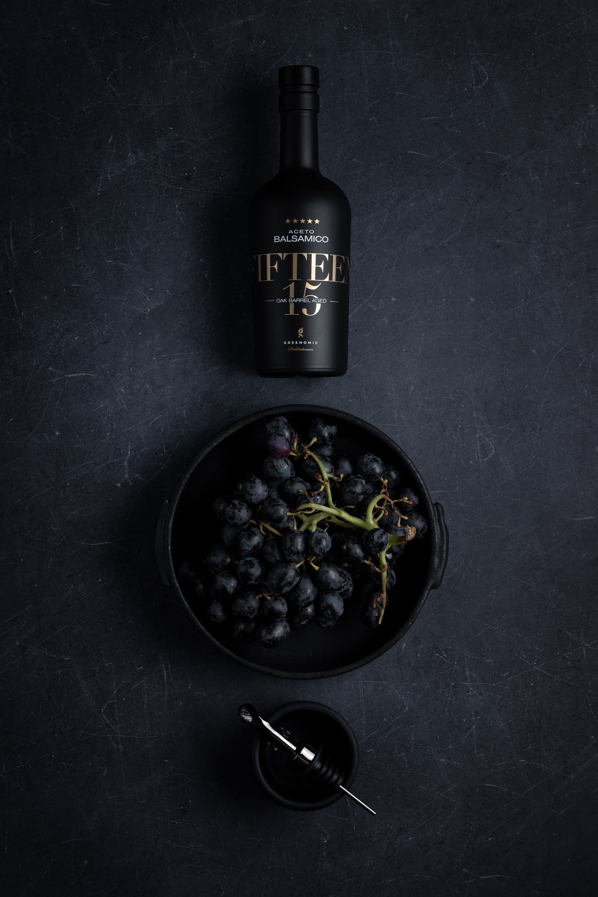 Balsamico FIFTEEN in schwarzer Keramikflasche mit Trauben
