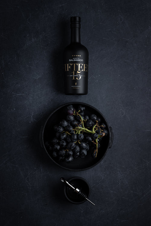 Balsamico FIFTEEN in schwarzer Keramikflasche mit Trauben
