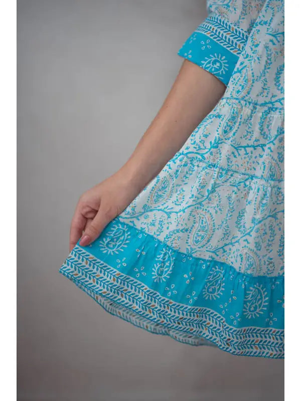 Detailansicht des Saums am blauen Paisley-Kleid
