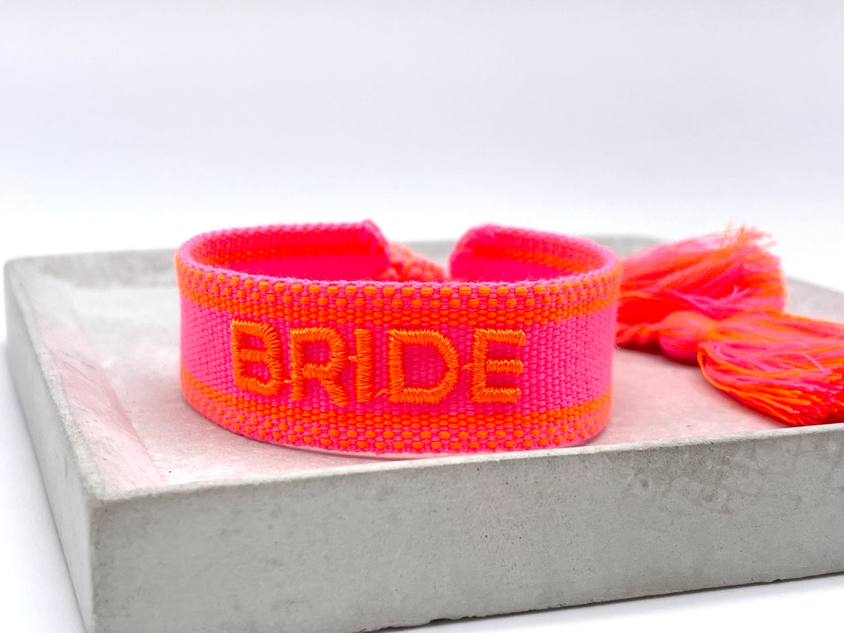 Gewebtes Statement-Armband „BRIDE" in Neon Pink mit oranger Stickerei und Neon-Quasten – Produktfoto - el encanto